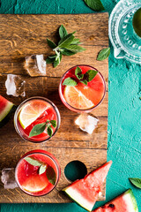 Non-alcoholic watermelon mojito drink. Served on wooden chopping board.