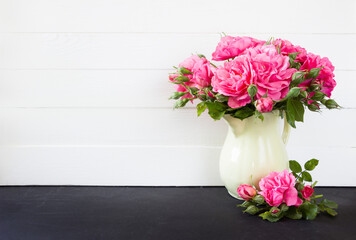 Pink roses bouquet in vase, white wooden background. Empty  blank mock up, poster product design