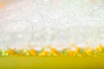 Blurred abstract light background with yellow bubbles. The concept is summer, soft drinks, freshness. For the backing of a site or mobile application.