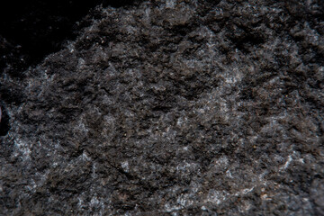 Photo of a coal surface in soft focus at high magnification. Fine texture of a natural mineral of black color with a blurred background. Natural fuel, non-renewable resource.