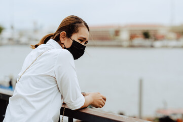 young woman relaxing  and travel in the city with face mask in thailand