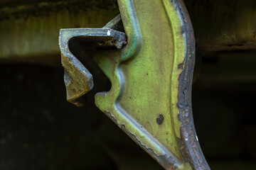 Close-up of a powerful fastening element on a railway carriage painted green with partially peeling paint