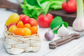 tomatoes, salad and garlic on kitchen table with knife close-up