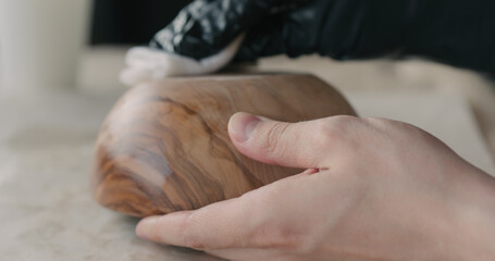 woodworker applying oil finish to olive wood bowl