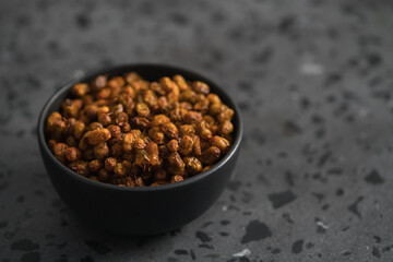dried seaberry buckthorn in black bowl on terrazzo countertop with copy space
