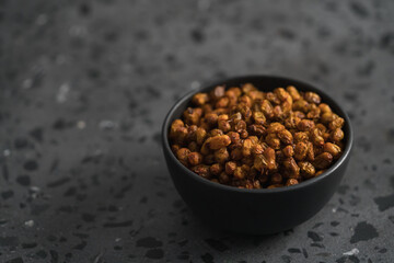 dried seaberry buckthorn in black bowl on terrazzo countertop with copy space