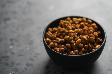 dried seaberry buckthorn in black bowl on terrazzo countertop with copy space