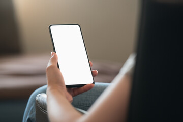 Young woman sitting in chair with modern smartphone with white screen