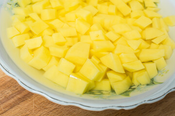 Raw sliced potatoes lay in plate of water to get rid of nitrates and nitrites.
