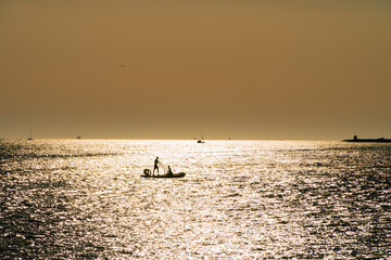 Fototapeta premium man in a boat backlight with reflections on the mediterranean sea