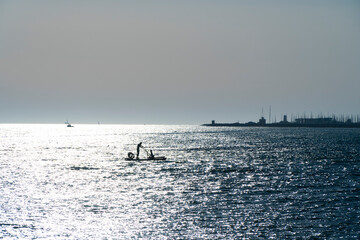 man in a boat backlight with reflections on the mediterranean sea
