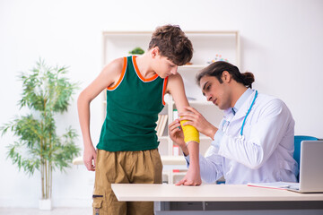 Sick boy visiting young male doctor pediatrician