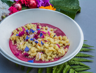 gnocchi with carrot cream and cornflower. Plate decorated with mallow flowers. Flower food concept. edible summer flowers