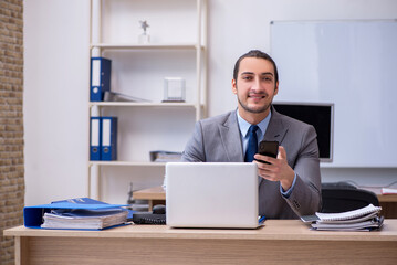 Naklejka premium Young male businessman employee working in the office