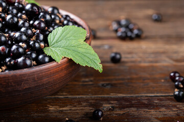 Black currants in the brown bowl .