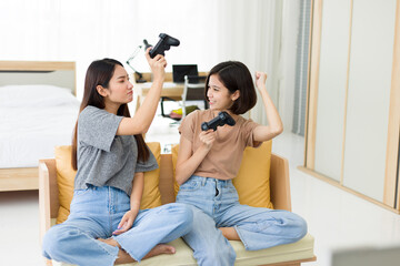 Two young women playing video games at home.