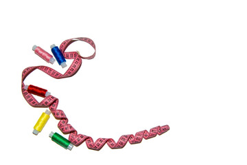 Multi-colored sewing threads with a sewing tape on a white background. The view from the top. The image has space for the caption