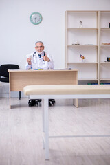 Old male doctor working in the clinic