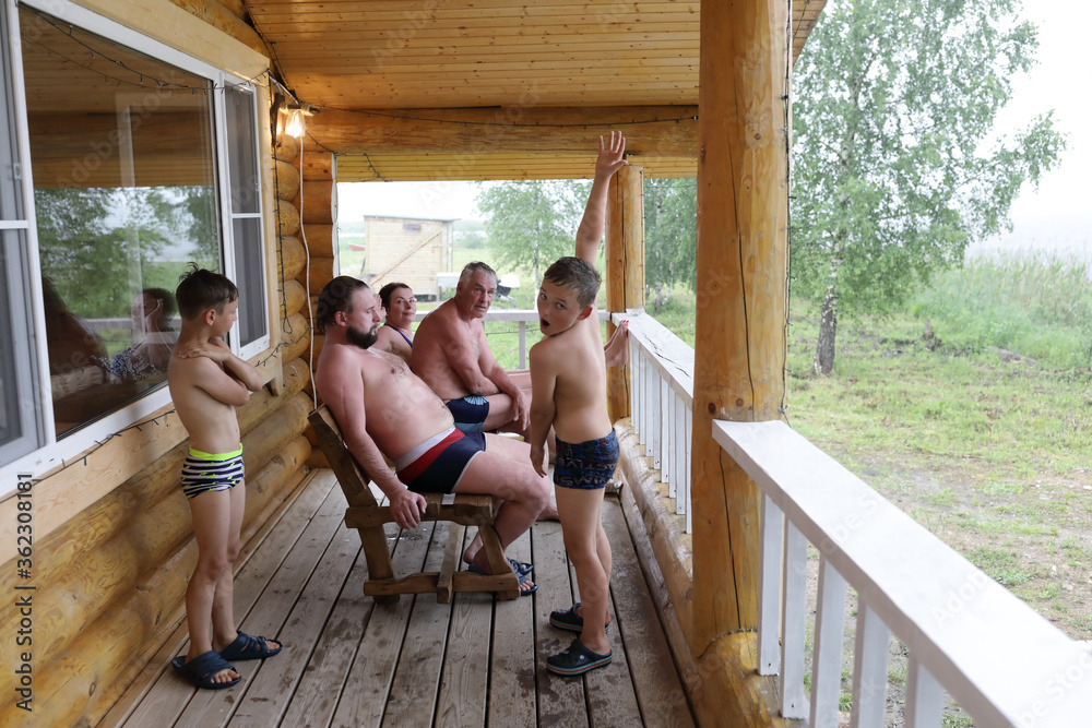 Wall mural Family resting on wooden terrace