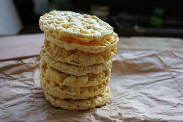 Whole grain crispbreads on craft paper texture. Crispy puffed rice or corn cakes. Healthy snack, or...