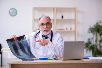 Old male doctor working in the clinic