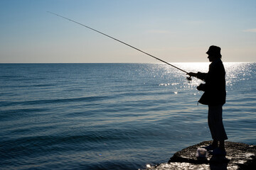 silhouette of a fisherman by the sea