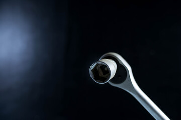 Used ratchet wrench close up shot on dark background, highlighted area for space.