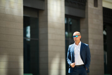 handsome young man in a summer suit on a walk in sunglasses
