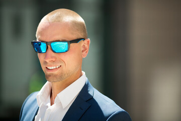handsome young man in a summer suit on a walk in sunglasses