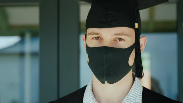 Graduate in a protective mask and cap, graduating from college under quarantine