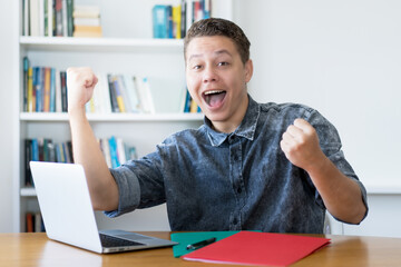 German young adult watching sports online at computer