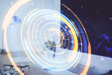 Computer on desktop in office with technology theme hologram. Double exposure. Tech concept.