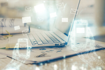 Desktop computer background in office and flying envelops hologram drawing. Multi exposure. Electronic mail concept.