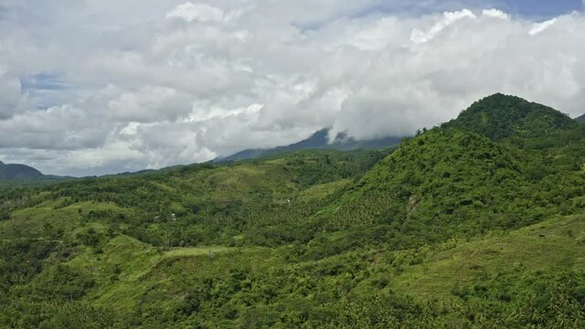 The Lush Green Mountains And Meadow Under The Beautiful White Fluppy Clouds In The Philippines. - aerial drone