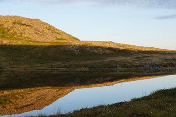 A lake in the tundra and mountain is reflected in it,  Cola peninsula,  Arctic Russia 