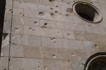 Traces of bullets and splinters on the wall of the building after shelling the city 