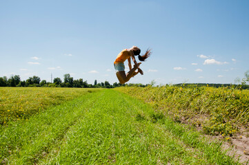 Free Happy Woman. Flexible girl jump in field. happiness in motion. celebrating success. just have fun. keep moving. enjoying active summer vacation. full of energy. inspired with sport and strength