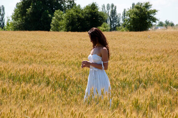 Fototapeta na wymiar Boho style clothing. sensual woman hold spikelet torn in wheat field. female beauty and summer fashion. Autumn girl enjoy nature. Beautiful bride on wedding day. Young woman in wedding dress outdoors