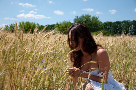 Woman enjoying nature in meadow. sexy girl collect wildflowers. pure sensuality and sexuality. innocent girl sit among spikelet. relax in summer field. hippy girl holding bouquet of wildflowers