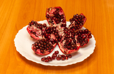 broken pomegranate on a white plate on the table