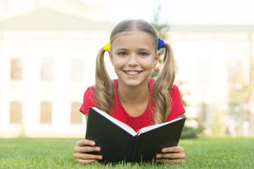 Open your imagination, read. Happy kid read book on green grass. Developing imagination. Childhood imagination. Imagination and fantasy. Cognitive reading skills. Summer reading. Become imaginative