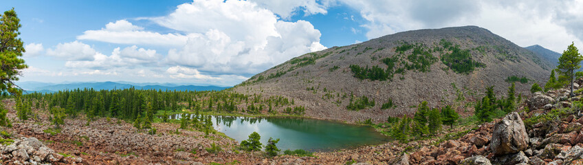 Fototapeta na wymiar Shushensky Bor. Banzai Lake. View of the lake, forest and mountains. Panorama