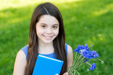 Fototapeta premium Happy childrens day. Happy girl got flowers for childrens day. Little child on summer outdoor. Childrens day celebration. Happy childhood. June 1. November 20. International childrens day