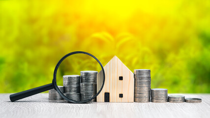 Saving money concept preset by coins stack and wooden house model with blurred green nature background. Investment plan growing business