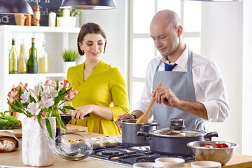 Smiling young couple cooking food in the kitchen