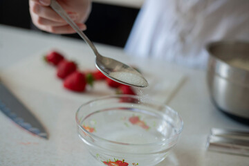 A young girl pours sugar into a cream. Cooking Cake Cream