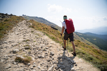 photo of a traveler with a backpack climbing to mountains