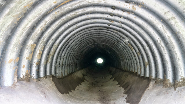 Drainage pipe under highway (culvert). Filming inside pipe.
