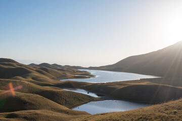 Morning Sunlight Landscape of Tulpar Kol Lake in Alay Valley, Osh, Kyrgyzstan. Pamir mountains in...