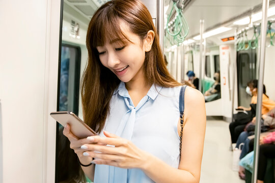 Young Woman Watching The Mobile  Phone In  Subway Train